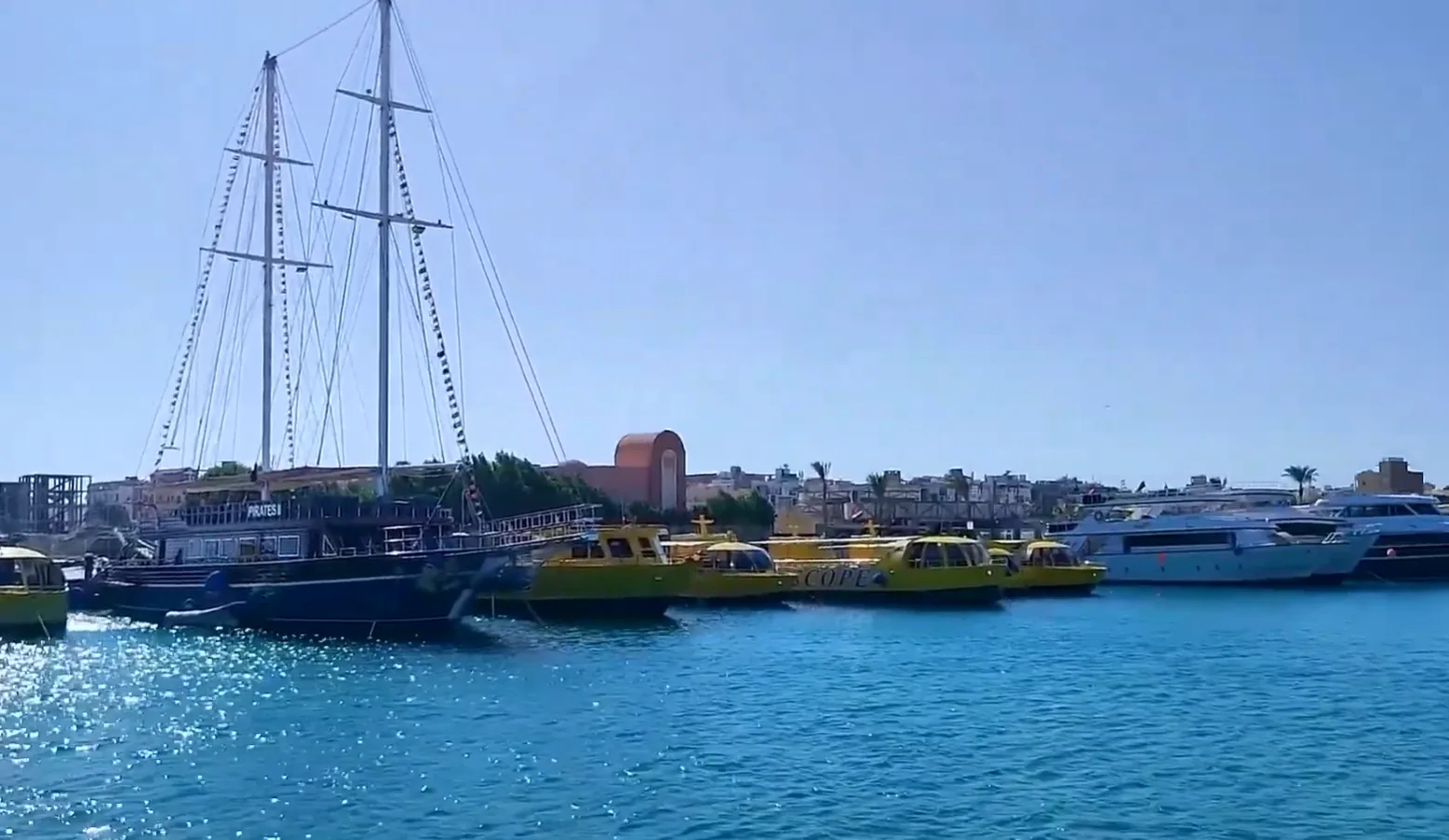 Royal Seascope's glass-bottom boats moored in the harbour, alongside the Pirates II sailing boat.